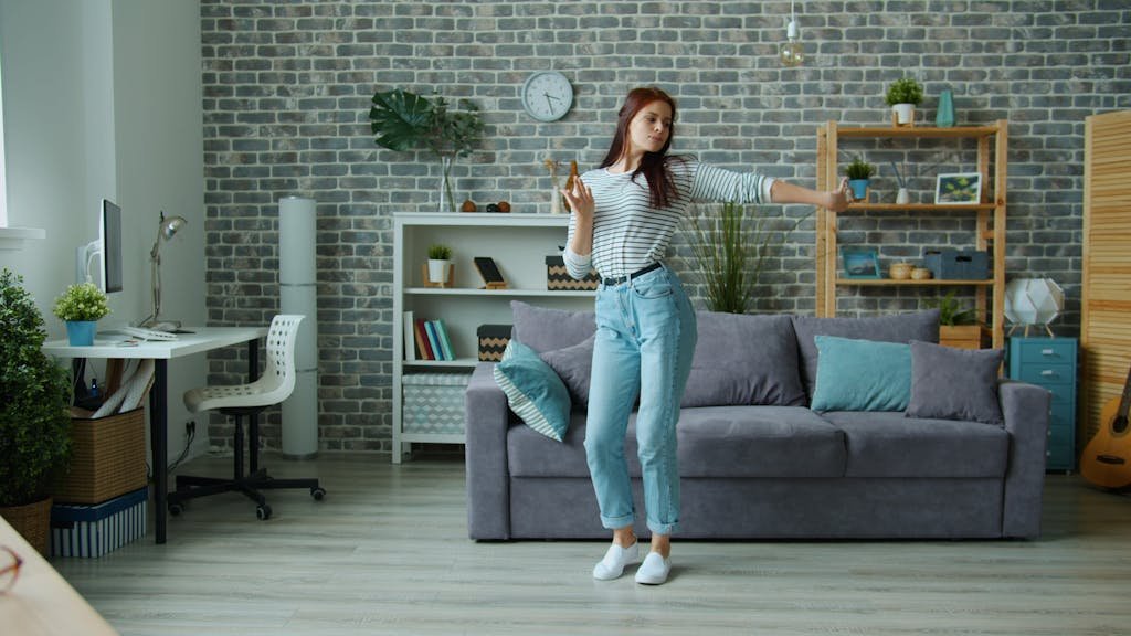 A woman enjoys dancing in a stylish living room space with modern decor.