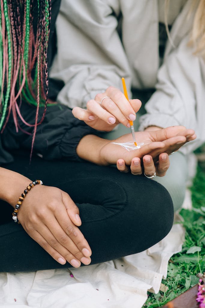 Close-up of artistic hand painting in an outdoor setting, focus on creativity and expression.