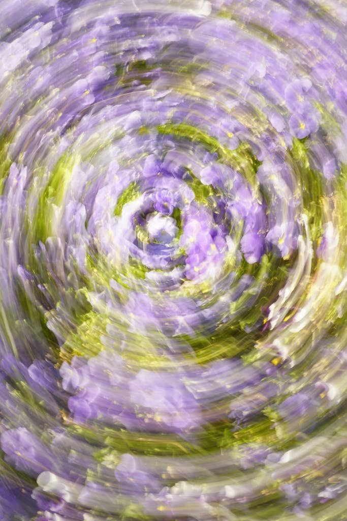 Vibrant abstract swirl with purple and green hues, creating a dynamic and artistic visual effect.