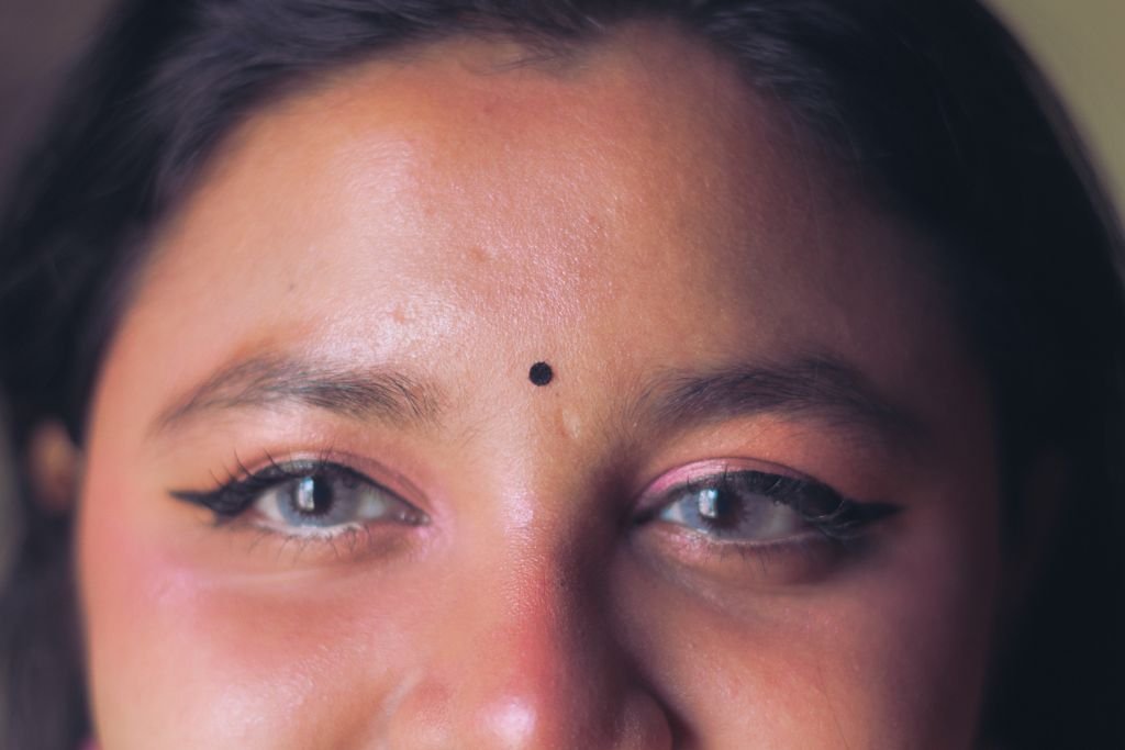 A detailed close-up of a woman's eyes with traditional bindi, conveying cultural beauty.