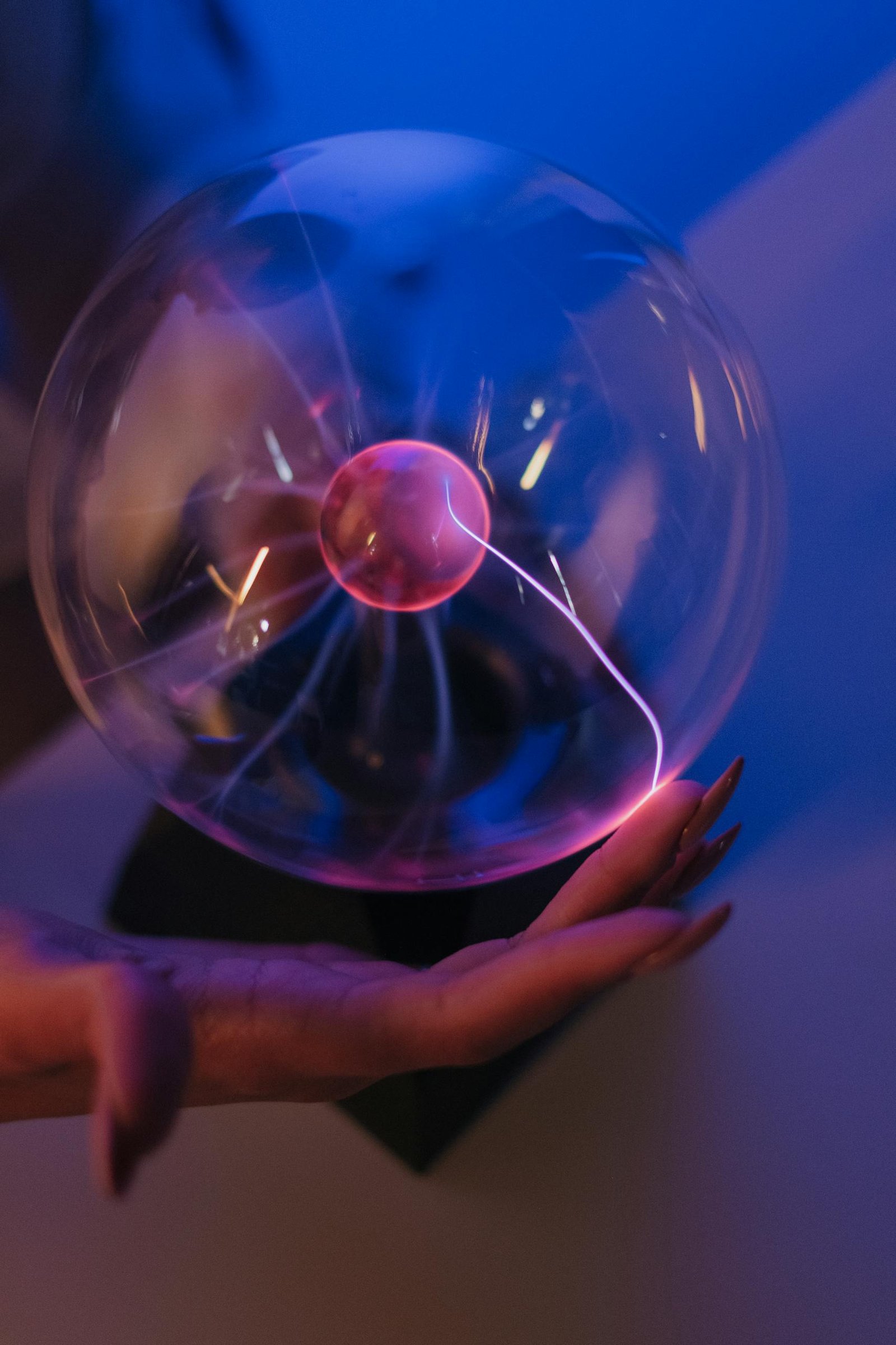 A mesmerizing plasma ball generating colorful electric arcs in a dark room, creating a scientific and futuristic vibe.