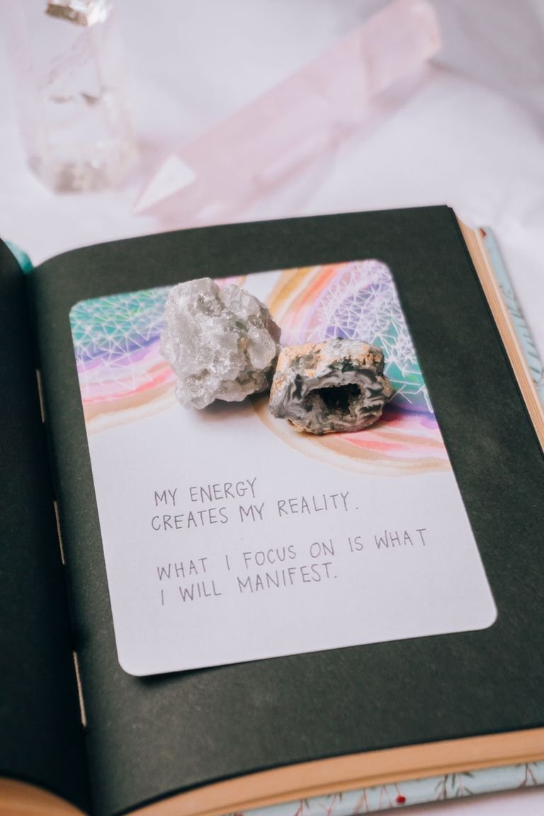 Open journal featuring crystals and an inspiring manifestation quote, perfect for motivation seekers.